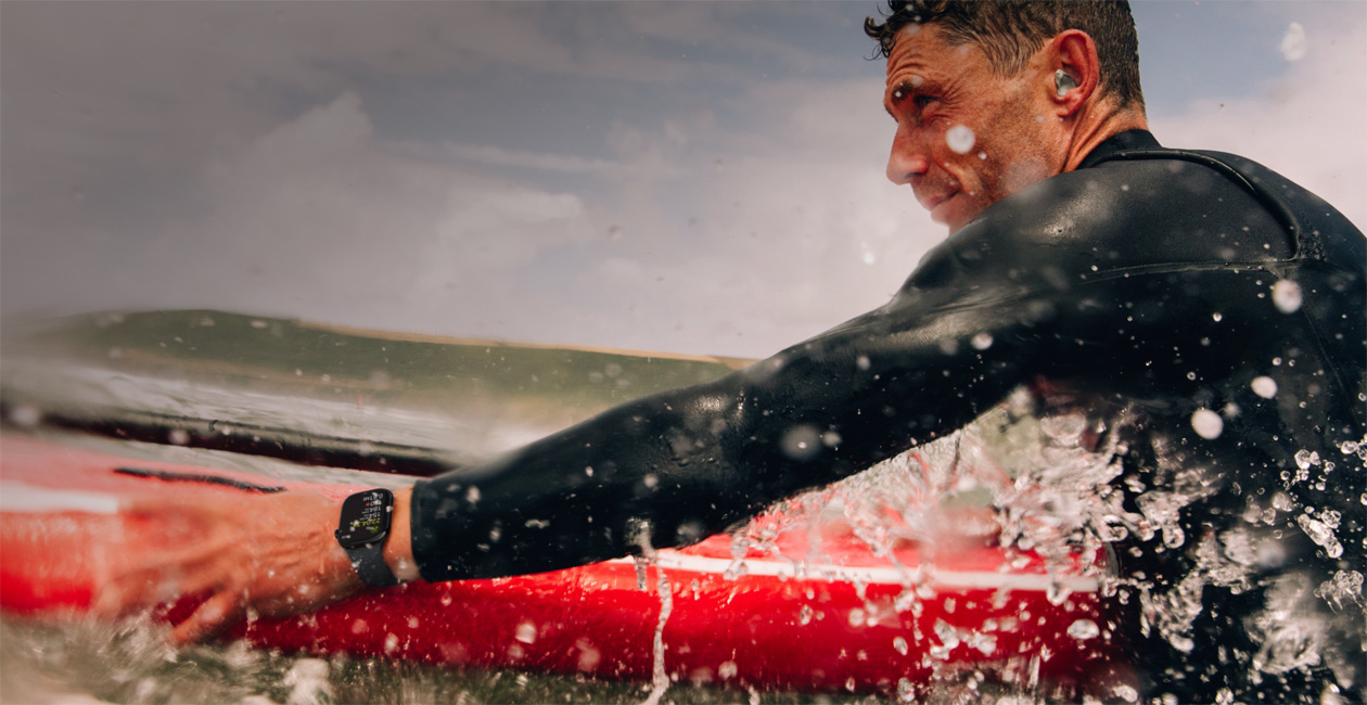 Un hombre hace surf con un Apple Watch puesto.